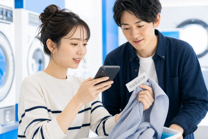 スマートフォンのカメラで情報を見せる二人の場面