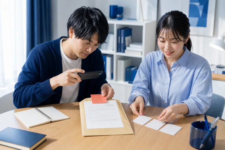 書類を写真でAIに相談する二人の場面